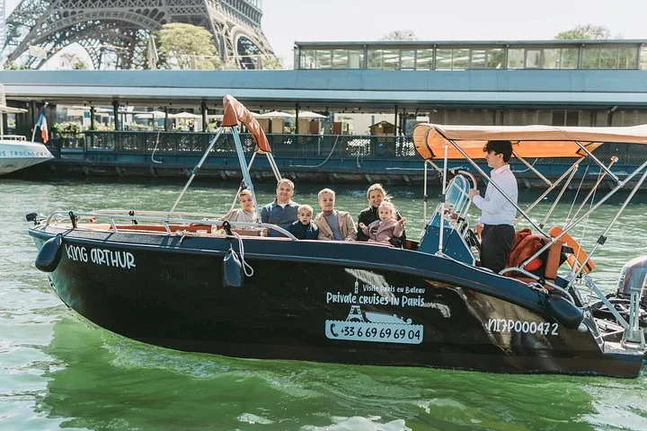 A private boat with its group passing a riverside terrace
