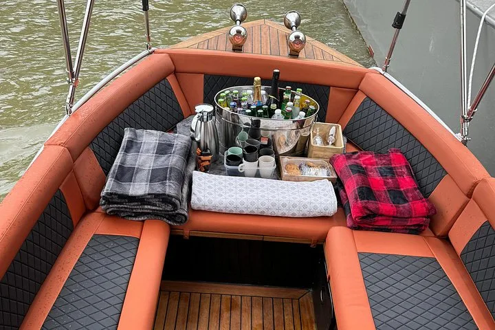 The orange-cushioned seating of a larger boat, set for guests