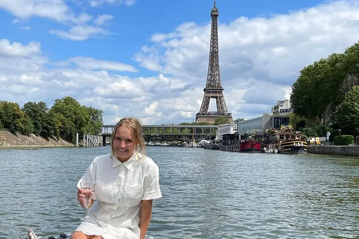 A guest with a glass in front of the Eiffel Tower