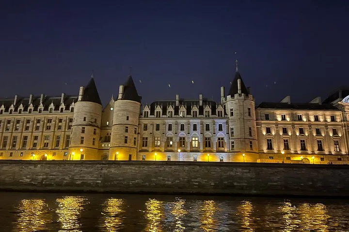 The Conciergerie lit at night across the water